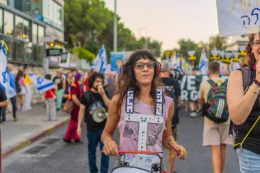Hayfa, İsrail - 30 Ağustos 2025: İnsanlar savaşın sona ermesi, rehine anlaşmasının tamamlanması ve yeni seçimler çağrısında bulunan bir protesto yürüyüşüne (Pembe Cephe Grubu) katılıyor. Hayfa, İsrail