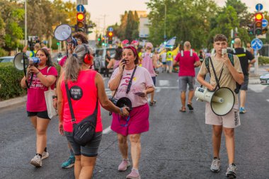Hayfa, İsrail - 30 Ağustos 2025: İnsanlar savaşın sona ermesi, rehine anlaşmasının tamamlanması ve yeni seçimler çağrısında bulunan bir protesto yürüyüşüne (Pembe Cephe Grubu) katılıyor. Hayfa, İsrail