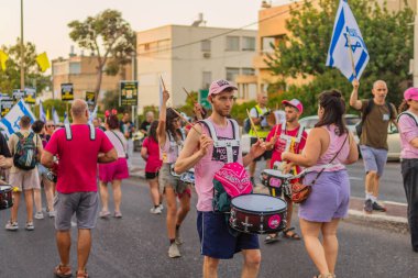 Hayfa, İsrail - 30 Ağustos 2025: İnsanlar savaşın sona ermesi, rehine anlaşmasının tamamlanması ve yeni seçimler çağrısında bulunan bir protesto yürüyüşüne (Pembe Cephe Grubu) katılıyor. Hayfa, İsrail