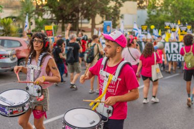 Hayfa, İsrail - 30 Ağustos 2025: İnsanlar savaşın sona ermesi, rehine anlaşmasının tamamlanması ve yeni seçimler çağrısında bulunan bir protesto yürüyüşüne (Pembe Cephe Grubu) katılıyor. Hayfa, İsrail