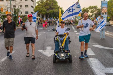 Hayfa, İsrail - 30 Ağustos 2025: Çeşitli tabela ve bayraklara sahip insanlar savaşın sona ermesi, rehine anlaşmasının tamamlanması ve yeni seçimler için düzenlenen protesto mitingine katıldılar. Hayfa, İsrail
