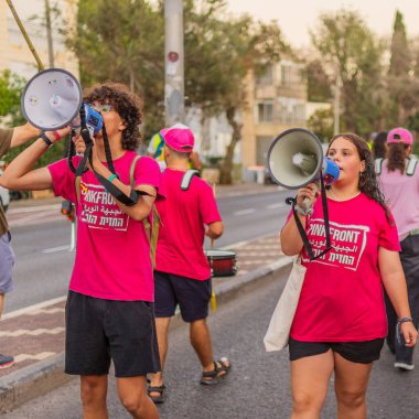 Hayfa, İsrail - 30 Ağustos 2025: İnsanlar savaşın sona ermesi, rehine anlaşmasının tamamlanması ve yeni seçimler çağrısında bulunan bir protesto yürüyüşüne (Pembe Cephe Grubu) katılıyor. Hayfa, İsrail