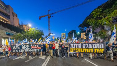 Hayfa, İsrail - 30 Ağustos 2025: Çeşitli tabela ve bayraklara sahip insanlar savaşın sona ermesi, rehine anlaşmasının tamamlanması ve yeni seçimler için düzenlenen protesto mitingine katıldılar. Hayfa, İsrail