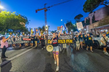 Hayfa, İsrail - 30 Ağustos 2025: Çeşitli tabela ve bayraklara sahip insanlar savaşın sona ermesi, rehine anlaşmasının tamamlanması ve yeni seçimler için düzenlenen protesto mitingine katıldılar. Hayfa, İsrail