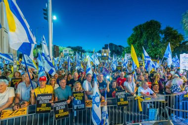 Hayfa, İsrail - 30 Ağustos 2025: Çeşitli tabela ve bayraklara sahip bir grup insan, savaşın sona ermesi, rehine anlaşmasının tamamlanması ve yeni seçimler için düzenlenen protesto mitingine katıldı. Hayfa, İsrail