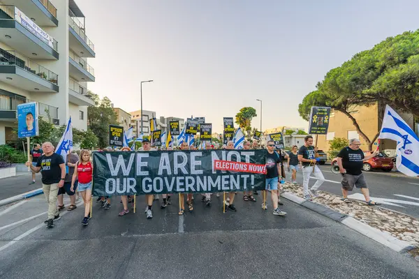 Hayfa, İsrail - 30 Ağustos 2025: Çeşitli tabela ve bayraklara sahip insanlar savaşın sona ermesi, rehine anlaşmasının tamamlanması ve yeni seçimler için düzenlenen protesto mitingine katıldılar. Hayfa, İsrail