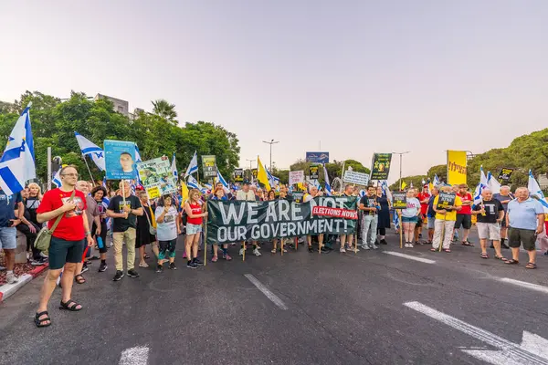 Hayfa, İsrail - 30 Ağustos 2025: Çeşitli tabela ve bayraklara sahip insanlar savaşın sona ermesi, rehine anlaşmasının tamamlanması ve yeni seçimler için düzenlenen protesto mitingine katıldılar. Hayfa, İsrail