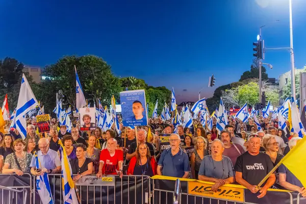 Hayfa, İsrail - 30 Ağustos 2025: Çeşitli tabela ve bayraklara sahip bir grup insan, savaşın sona ermesi, rehine anlaşmasının tamamlanması ve yeni seçimler için düzenlenen protesto mitingine katıldı. Hayfa, İsrail