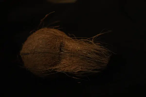 Siyah arka planlı bir hindistan cevizinin yakın plan fotoğrafı.