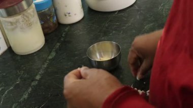 Bir adam elinde bir bardak süt tutuyor.