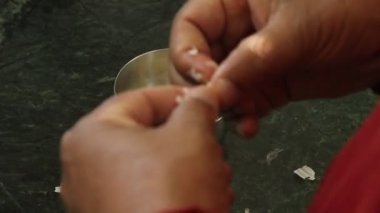 Yakından bakınca, tırnak cilası yapan erkek elleri görülüyor.