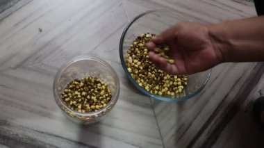 Bir kâse kahve çekirdeği tutan bir adamın ellerini yakın çekim.