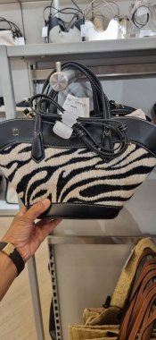 a closeup shot of a female hand holding a black bag