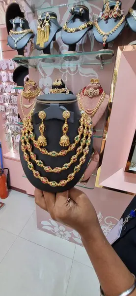 Piyasada kolye tutan bir kadın.