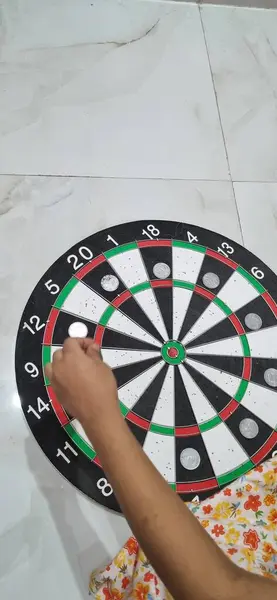 Dartla dart tahtasını tutan el.