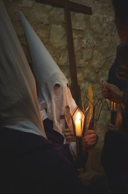 Brihuega 'daki Kutsal Hafta Sessizlik Yürüyüşü' nde elinde mum tutan genç bir Nasıralı 'nın beyaz bir şapkayla fotoğrafı.