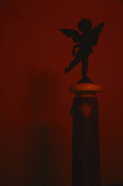 07-11-2013 Florence, İtalya - Melek heykeli kırmızı ışıklı Vecchio Sarayı 'nın duvarına gölge düşürdü