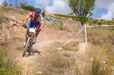 03-08-2014 Brihuega, İspanya - Bisikletçi Brihuega 'daki MTB yarışında kuru ve sıcak bir günde yokuş aşağı kayıyor