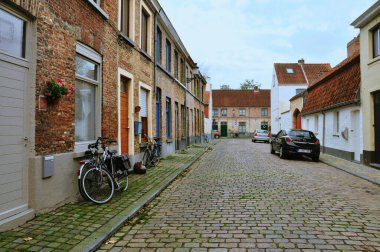 30-10-2014 Bruges, Belçika - Bruges 'de tipik ev ve bisikletlerin yer aldığı pitoresk bir kaldırım taşı caddesi