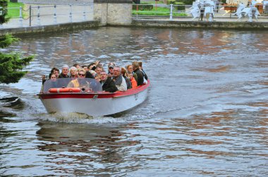 30-10-2014 Bruges, Belçika - Turistli bir tekne Bruges 'ün manzaralı kanallarının keyfini çıkarıyor