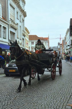30-10-2014 Bruges, Belçika - Belçika 'nın pitoresk ortaçağ şehri Bruges' deki kaldırım taşı caddelerinde at arabasıyla geziyor