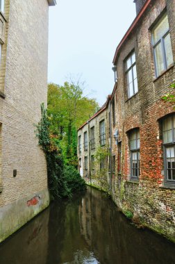 30-10-2014 Bruges, Belçika - Bruges 'deki geleneksel tuğla evlerin arasından akan dar bir kanalın resimsel bir sahnesi