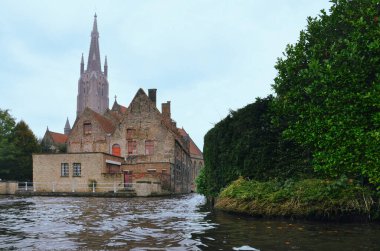 30-10-2014 Brüksel, Belçika - Geleneksel evler Bruges kanalı, arka planda kilise kulesi, tekneden izleniyor