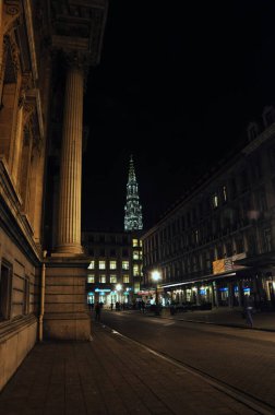 30-10-2014 Brüksel, Belçika - Arka planda ışıklı belediye kulesi bulunan sokak lambalarıyla aydınlatılan Brüksel Caddesi