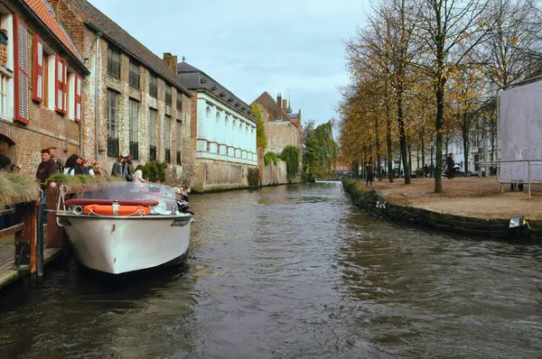 30-10-2014 Brüksel, Belçika - Bruges Kanalı 'na kenetlenmiş bir teknenin manzaralı manzarası, ağaçlarla kaplı bir patika.