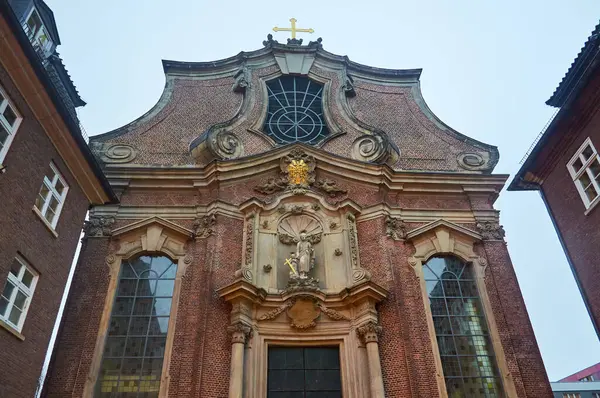 Hamburg 'daki Aziz Joseph Kilisesi' nin tuğla cephesinde güzel pencereler ve merkezi bir heykel yer alıyor.