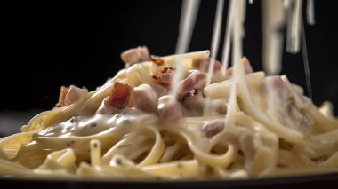 Domates soslu lezzetli iştah açıcı klasik İtalyan spagetti makarna peynir parmesan ve fesleğen plaka karanlık tablo üzerinde. Yukarıdan, yatay görüntüleme