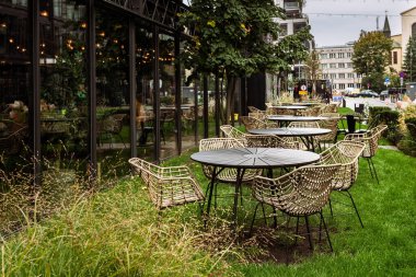 Yerleşim alanındaki yeşil çimlerde masa ve sandalyeler.