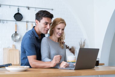 Odada kucaklaşan orta yaşlı, yakışıklı bir çift. Mutfak odasında kahvaltı yaparken dizüstü bilgisayar kullanan mutlu karı ve koca. Evdeki yeni normal iş hayatı.