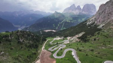 Dolomites dağ geçidinde dolambaçlı yolda giden arabaların hava manzarası.