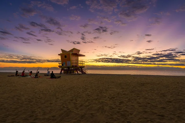 Sunrise at one of the famous life guard houses in Miami Beach, Florida, USA with a Yoga team doing exercises