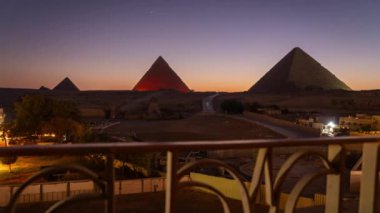 Kahire yakınlarındaki Giza 'daki 3 ünlü piramidin ışık gösterisiyle günden geceye geçiyor. Yakınlardaki bir otelin çitlerinden kaçırılmış.
