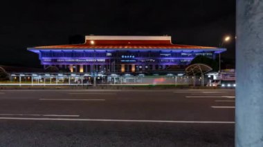 Gece Taipei 'deki (Tayvan) ana tren istasyonunun önündeki trafiğin hızlandırılmış klibi