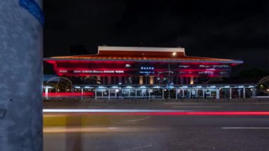 Gece Taipei 'deki (Tayvan) ana tren istasyonunun önündeki trafiğin hızlandırılmış klibi