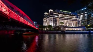 Gece vakti, kırmızı ışıkta geçen Anderson Köprüsü ve Singapur 'daki Fullerton Oteli' nden geçen turist tekneleri. Zaman aşımı klibi