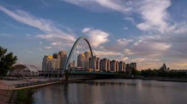 Kazakistan, Astana 'da Ishim Nehri' ni geçen modern bir yol köprüsünde gün batımının hızlandırılmış bir klibi.