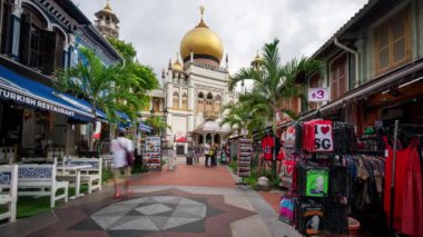 Arka planda Sultan Camii (Mescid Sultan) ile Singapur 'da Arap Caddesi' nde gezinen insanlar