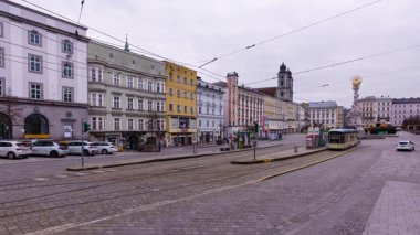 Linz, Avusturya 'da halk ve tramvaylar ana meydanda (Hauptplatz). Zaman aşımı klibi