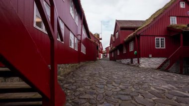 Faroe Adaları 'ndaki Torshavn' da (Tinganes) güzel kırmızı evi olan eski kasabanın önünde zaman klibi