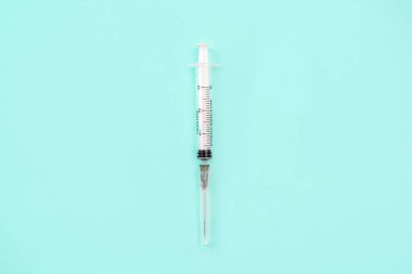 Syringe and needles on color background