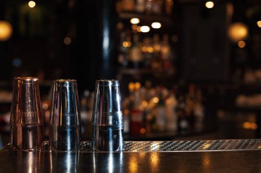 Ürün görüntüsü veya görsel montaj için ahşap masanın tepesini bulanık raflar ve şişelerle indirin