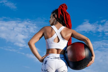 background sky. From the back. Athletic woman with med ball. Str