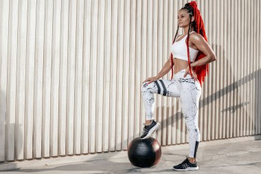 Athletic woman put my foot on med ball. Strength and motivation.
