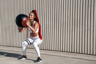 Athletic woman doing exercise squat with med ball. Strength and 