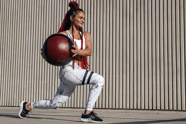 Athletic woman doing Lunge exercises with med ball. Strength and