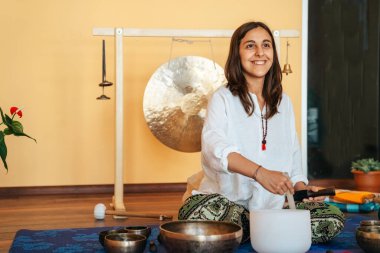 Female instructor Tibetan singing bowl in sound therapy
